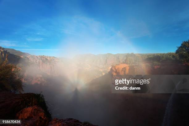 brocken spectre and rainbow over waterfall in ouzoud morocco - brocken spectre stock pictures, royalty-free photos & images