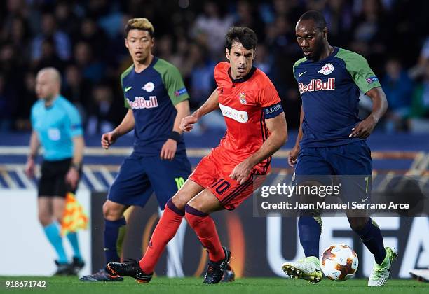 Reinhold Yabo of FC Red Bull Salzburg being followed by Xabier Prieto of Real Sociedad during UEFA Europa League Round of 32 match between Real...