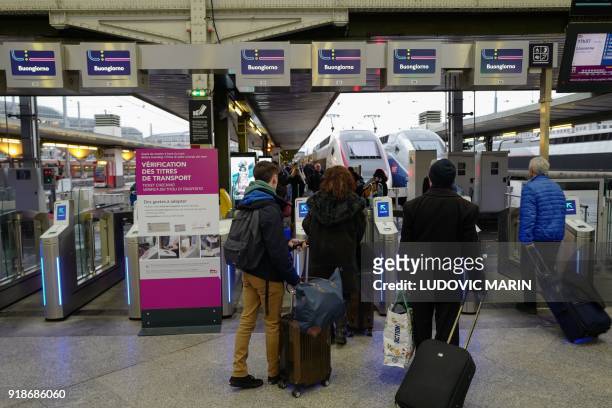 Passengers board a Lyria SNCF Lausanne bound train at the Gare de Lyon railway station on Febuary 15, 2018 in Paris. - A report submitted on February...