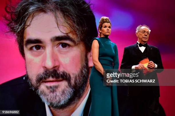 German TV host Anke Engelke and Berlinale Director Dieter Kosslick stand on stage in front of a portrait of German journalist Deniz Yucel, held in...
