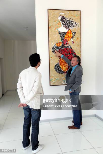 Painter Akmal Nur shows one of his painting during the Akmal Nur Exhibition opening at The Center of National Arts on October 13, 2009 in Tashkent,...