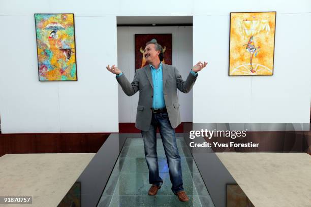 Painter Akmal Nur poses with his works during the Akmal Nur Exhibition opening at The Center of National Arts on October 13, 2009 in Tashkent,...