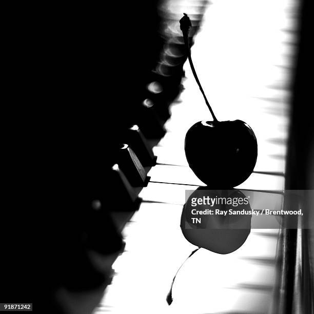 cherry in silhouette on piano keyboard - brentwood tennessee stock pictures, royalty-free photos & images