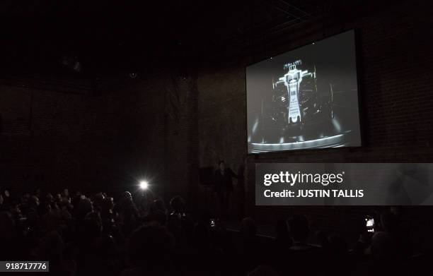 Photographers flash gun fires as the new car is unveiled on screen during the Williams Formula One 2018 season launch in London on February 15, 2018.