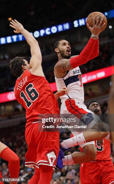 Mike Scott of the Washington Wizards drives between Paul Zipser and Bobby Portis of the Chicago Bulls at the United Center on February 10, 2018 in...