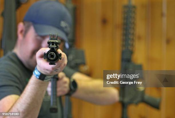 Dordon Brack, aims a semi-automatic AR-15 that is for sale at Good Guys Guns & Range on February 15, 2018 in Orem, Utah. An AR-15 was used in the...