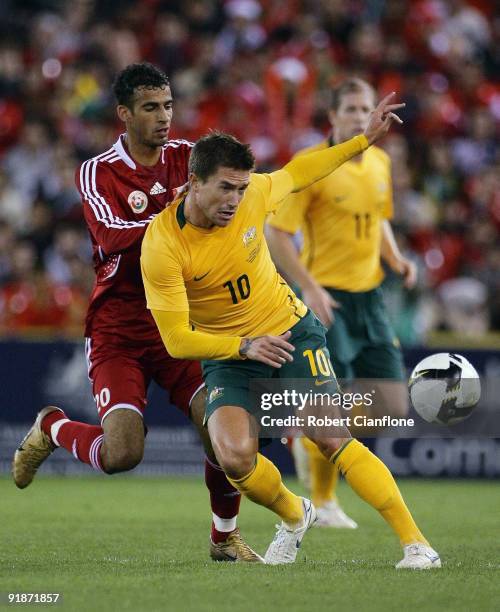 Harry Kewell of Australia is challenged during the Asian Cup Group B qualifying match between the Australian Socceroos and Oman at Etihad Stadium on...