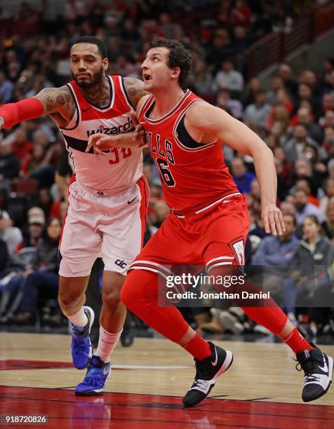 Paul Zipser of the Chicago Bulls and Mike Scott of the Washington Wizards battle for rebound position at the United Center on February 10, 2018 in...