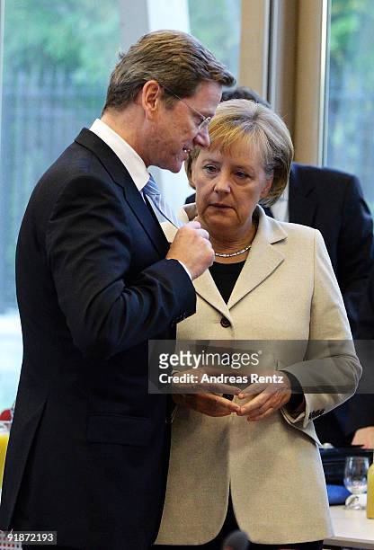 German Chancellor and Chairwoman of the German Christian Democrats Angela Merkel looks to Guido Westerwelle's tie, leader of the German Free...