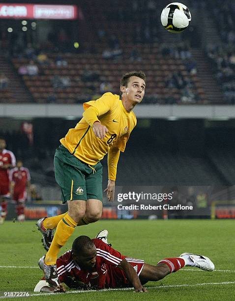 Luke Wiltshire of Australia is challenged by Hassan Rabia of Oman during the Asian Cup Group B qualifying match between the Australian Socceroos and...