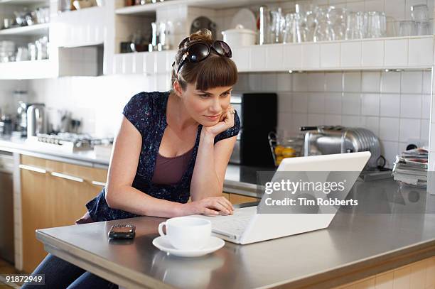 woman using laptop in kitchen - bang palabra en inglés fotografías e imágenes de stock