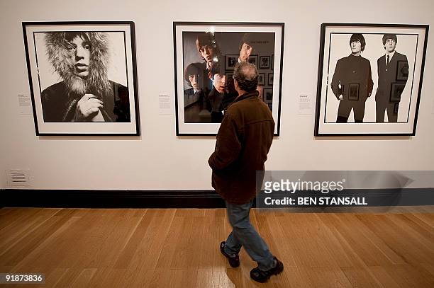 Man looks at a collection of photographic portraits by British photographer David Bailey featuring Mick Jagger , The Rolling Stones and John Lennon...