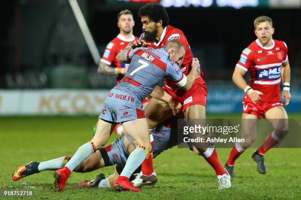 Mose Masoe of Hull KR is tackled by Luke Walsh and Benjamin Garcia of the Catalans Dragons during the BetFred Super League match between Hull KR and...