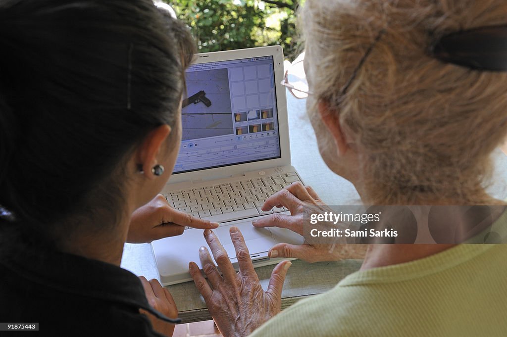 Girl showing Grandmother how to use laptop