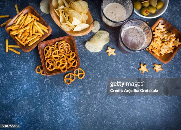 two glasses of beer and snacks on stone background with copy space - crisps foto e immagini stock