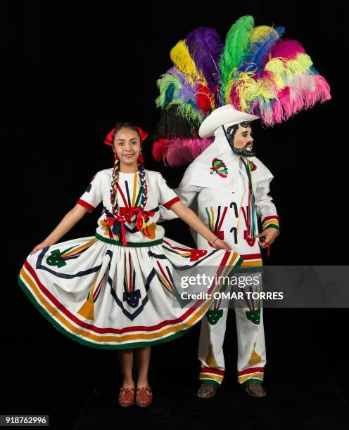 Kenia Vazquez and Paul Carro pose in their costumes for the carnival in Tlaxcala, Mexico on February 13, 2018. The satirical costumes and masks were...