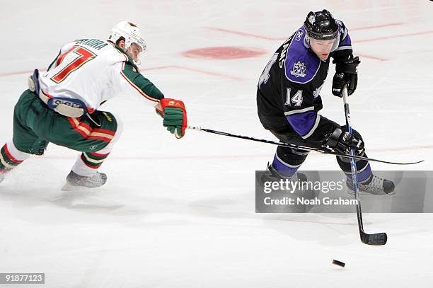 Justin Williams of the Los Angeles Kings skates with the puck against Petr Sykora of the Minnesota Wild on October 8, 2009 at Staples Center in Los...