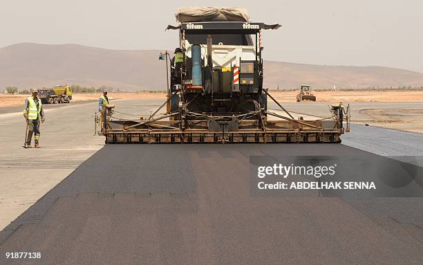 Moroccan worker drives a Caterpillar asphalt screed at construction site on July 21 of Oujda airport. French Colas and Moroccan GTR consortium won a...