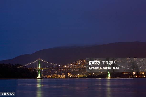 The Lions Gate Bridge is reflected in the harbor as seen in this 2009 Vancouver, British Columbia, Canada, early evening cityscape photo. This West...