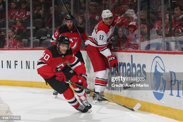 Blake Coleman of the New Jersey Devils pursues the puck against Trevor van Riemsdyk of the Carolina Hurricanes during the game at Prudential Center...