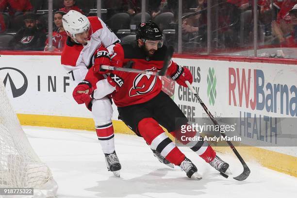 Kyle Palmieri of the New Jersey Devils battles for possession against Trevor van Riemsdyk of the Carolina Hurricanes during the game at Prudential...