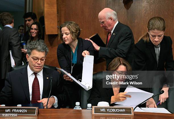 Chairman Patrick Leahy walks past Sen. Al Franken and Sen. Amy Klobuchar as they talk with aids during a Senate Judiciary Committee hearing on...