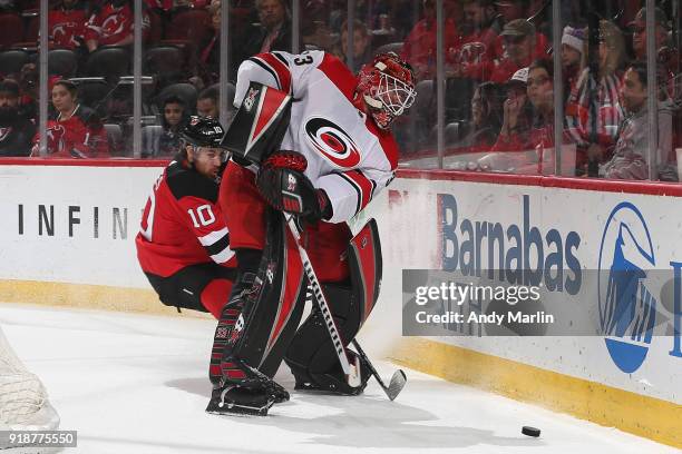 Scott Darling of the Carolina Hurricanes battles for possession against Jimmy Hayes of the New Jersey Devils during the game at Prudential Center on...