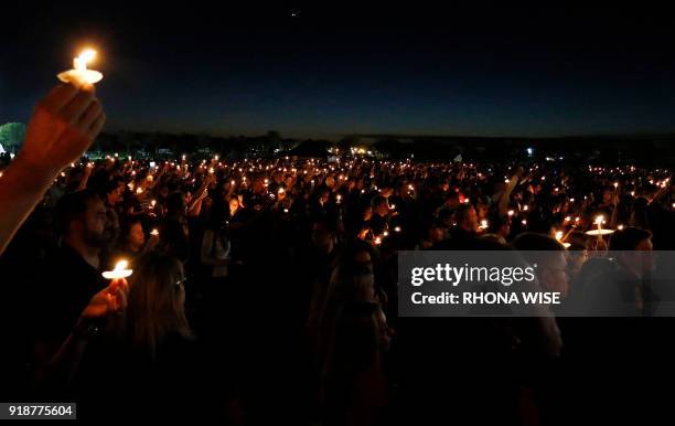 Thousands of mourners hold candles during a candlelight vigil for the victims of Marjory Stoneman Douglas High School shooting in Parkland, Florida...