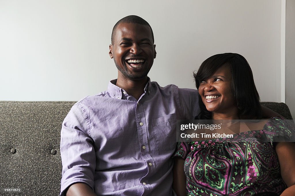 Mother and son laughing on couch, portrait