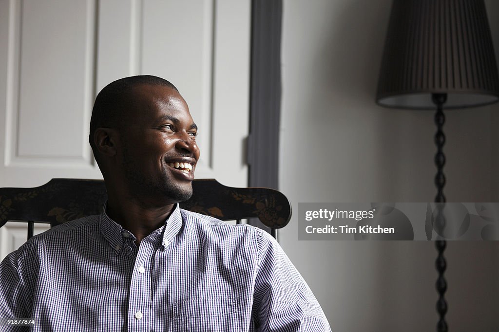 Man sitting in chair, laughing, profile