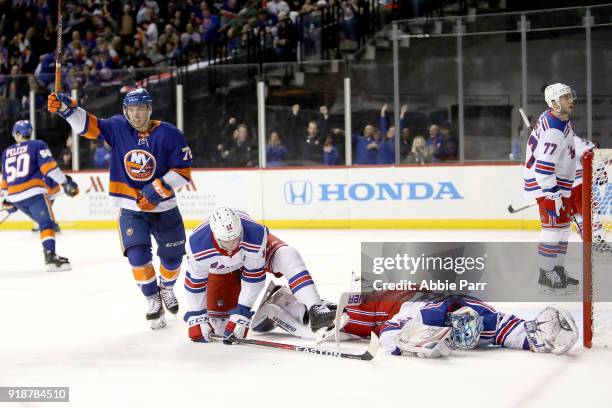 Henrik Lundqvist of the New York Rangers and Anthony Beauvillier of the New York Islanders react to a goal by Jordan Eberle of the New York Islanders...