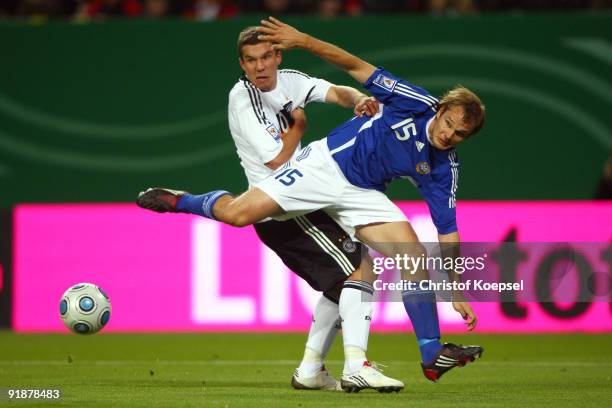 Markus Heikkinen of Finland challenges Lukas Podolski of Germany during the FIFA 2010 World Cup Group 4 Qualifier match between Germany and Finland...