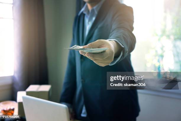 selective focus hand of business man offer money us dollar - exclusive offer foto e immagini stock