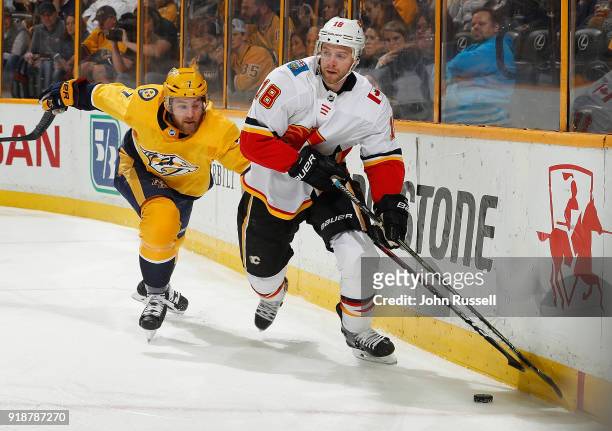 Matt Stajan of the Calgary Flames skates against Yannick Weber of the Nashville Predators during an NHL game at Bridgestone Arena on February 15,...