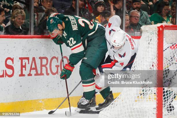 Nino Niederreiter of the Minnesota Wild and Taylor Chorney of the Washington Capitals battle for a loose puck during the game at the Xcel Energy...