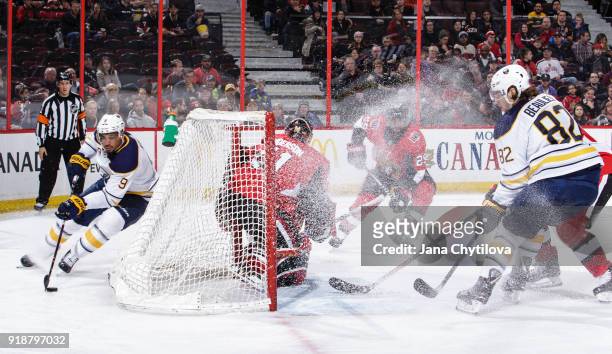 Evander Kane of the Buffalo Sabres skates with the puck behind the net as Craig Anderson and Johnny Oduya of the Ottawa Senators defend against...