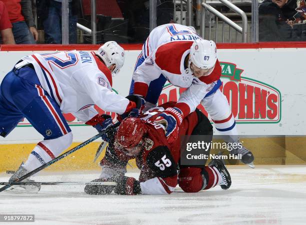 Jason Demers of the Arizona Coyotes is checked to the ice by Artturi Lehkonen and Max Pacioretty of the Montreal Canadiens during the first period at...