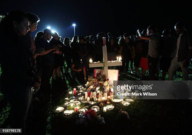 Students, friends, and family gather to pray during a candlelight vigil for victims of the mass shooting at Marjory Stoneman Douglas High School...