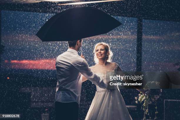 happily married couple dancing on a rain. - dancing in the rain stock pictures, royalty-free photos & images