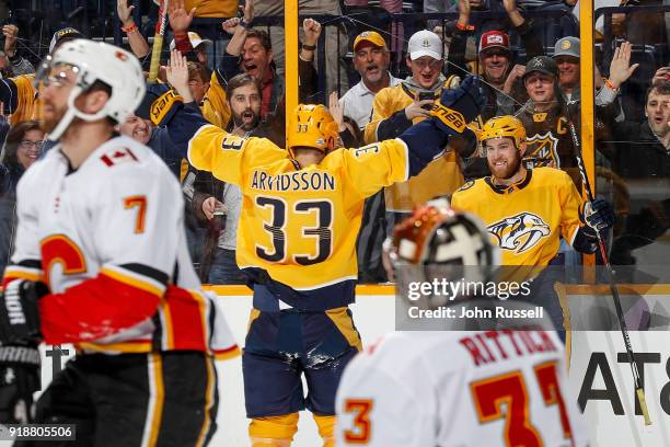 Yannick Weber celebrates his goal with Viktor Arvidsson of the Nashville Predators against goalie David Rittich of the Calgary Flames during an NHL...