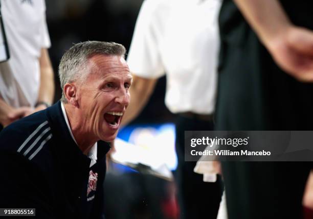 Head coach Mike Dunlap of the Loyola-Marymount Lions huddles with his team during a timeout in the first half against the Gonzaga Bulldogs at...