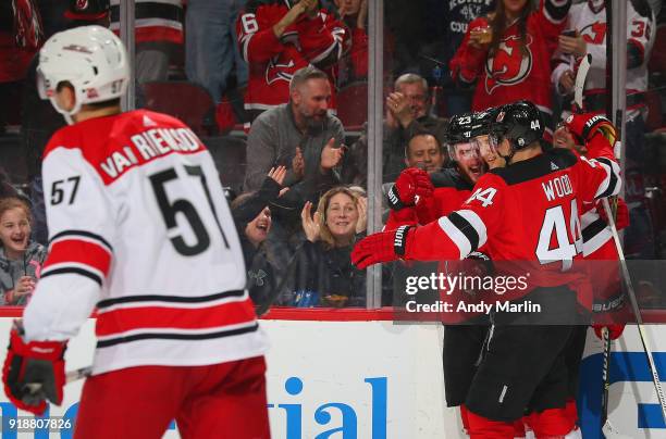 Stefan Noesen of the New Jersey Devils is congratulaed by his teammates after scoring a goal as Trevor van Riemsdyk of the Carolina Hurricanes skates...