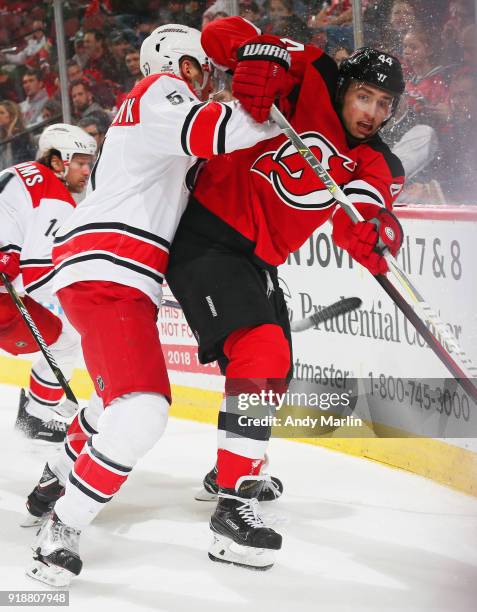 Miles Wood of the New Jersey Devils battles for position against Trevor van Riemsdyk of the Carolina Hurricanes during the game at Prudential Center...