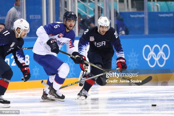 Lukas Cingel of Slovakia and Bobby Sanguinetti of the United States chase the puck during the Men's Ice Hockey Preliminary Round Group B game at...