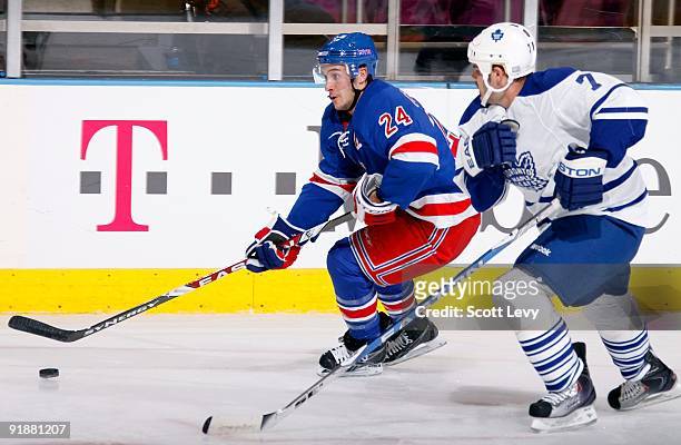 Ryan Callahan of the New York Rangers carries the puck as he skates against Ian White of the Toronto Maple Leafs on October 12, 2009 at Madison...
