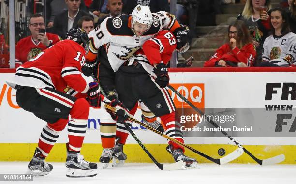 Artem Anisimov and Carl Dahlstrom of the Chicago Blackhawks battle for the puck with Antoine Vermette of the Anaheim Ducks at the United Center on...