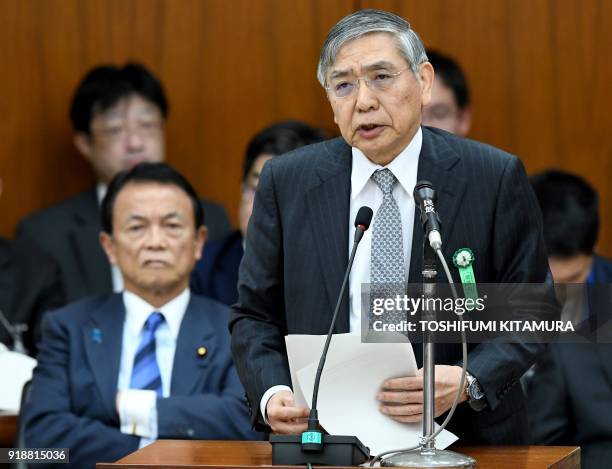 Bank of Japan governor Haruhiko Kuroda answers a question beside Japan's Finance Minister Taro Aso while attending a financial committee meeting of...