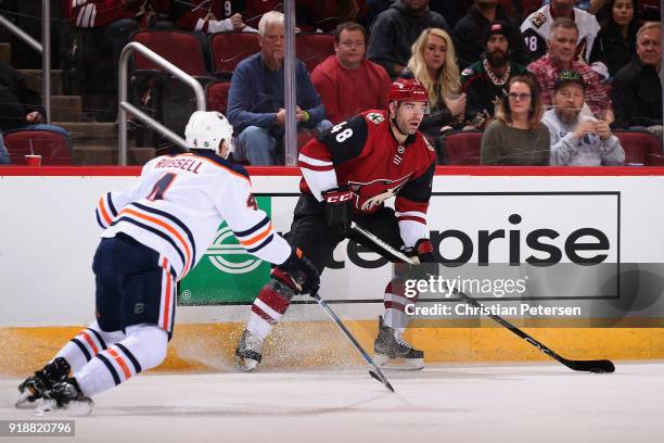 Jordan Martinook of the Arizona Coyotes looks to pass ahead of Kris Russell of the Edmonton Oilers during the first period of the NHL game at Gila...