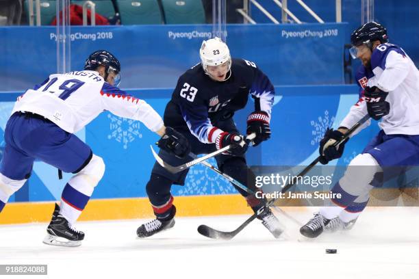 Troy Terry of the United States handles the puck against Tomas Starosta of Slovakia and Tomas Marcinko of Slovakia during the Men's Ice Hockey...