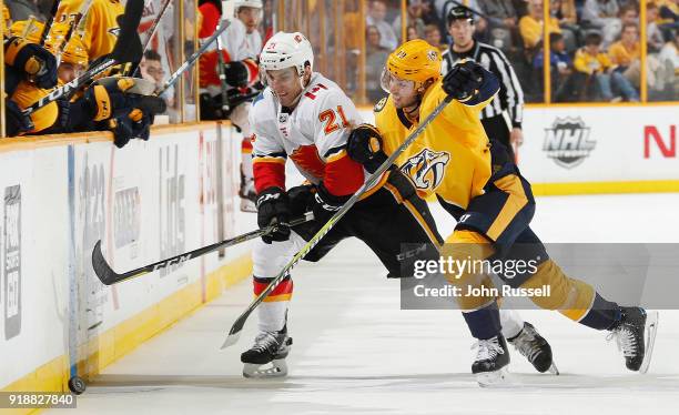 Garnet Hathaway of the Calgary Flames battles for the puck against Calle Jarnkrok of the Nashville Predators during an NHL game at Bridgestone Arena...